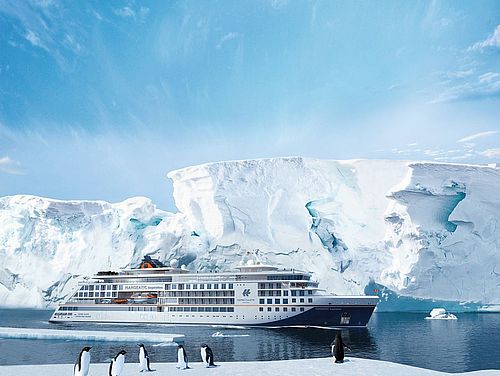 Kreuzfahrtschiff vor einem Eisberg mit Pinguinen im Vordergrund
